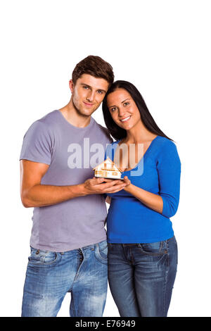 Young couple holding a model house Banque D'Images