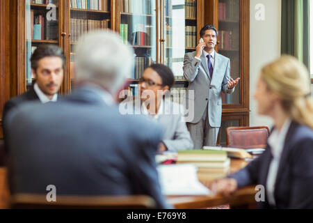 Les avocats talking on cell phone in chambers Banque D'Images