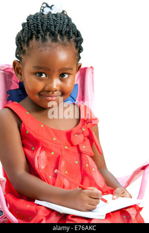 Close up portrait of cute little girl africaine avec carnet de notes.isolé sur fond blanc. Banque D'Images