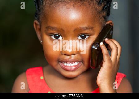 Faciale extrême portrait of cute girl africaine conversation sur téléphone intelligent. Banque D'Images