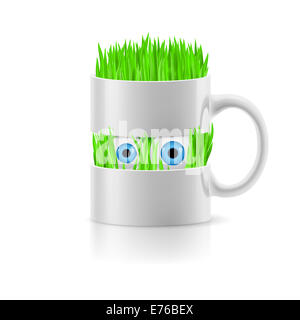 Mug blanc divisé en deux parties avec l'herbe et deux yeux à l'intérieur. Banque D'Images