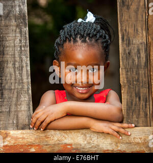 Close up portrait of pretty African youngster leaning on clôture en bois à l'extérieur. Banque D'Images