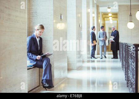 Juriste travaillant sur digital tablet in courthouse Banque D'Images