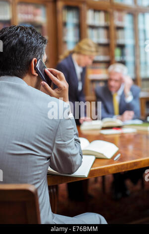 Avocat talking on cell phone in chambers Banque D'Images