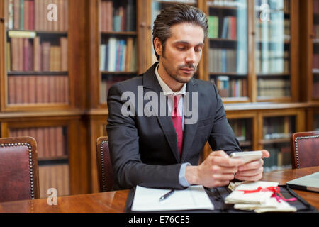 Juriste travaillant sur téléphone cellulaire en chambres Banque D'Images