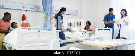 Médecin, infirmières et patients in hospital room Banque D'Images