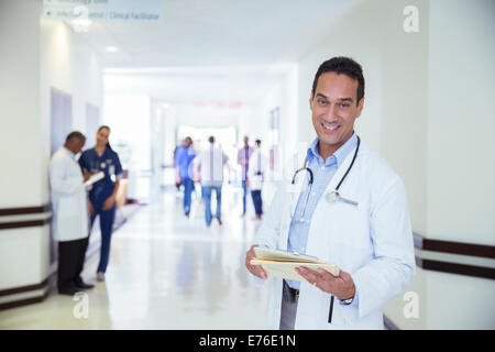 Doctor smiling in hospital hallway Banque D'Images