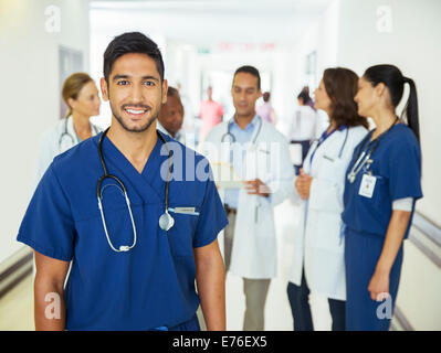 Nurse smiling in hospital hallway Banque D'Images