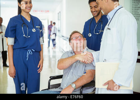 Médecin et patient shaking hands in hospital Banque D'Images