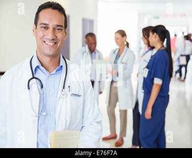 Doctor smiling in hospital hallway Banque D'Images