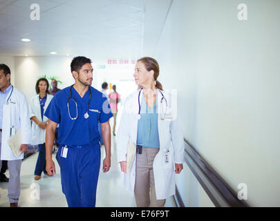Doctor and nurse talking in hospital hallway Banque D'Images