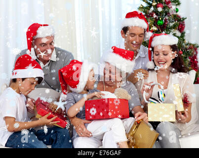 Image composite de l'ouverture de la famille des cadeaux de Noël à la maison Banque D'Images