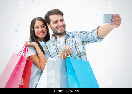 Image composite de l'attractive young couple with shopping bags selfies prendre une Banque D'Images