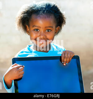 Close up portrait of little African girl pointing with finger at écran de l'ordinateur. Banque D'Images