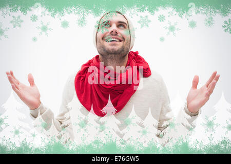 Composite image jeune homme dans des vêtements chauds avec hands up Banque D'Images