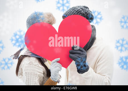 Composite image jeune couple dans des vêtements chauds holding red heart Banque D'Images