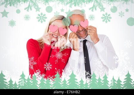 Image composite de silly couple holding cœurs sur les yeux Banque D'Images