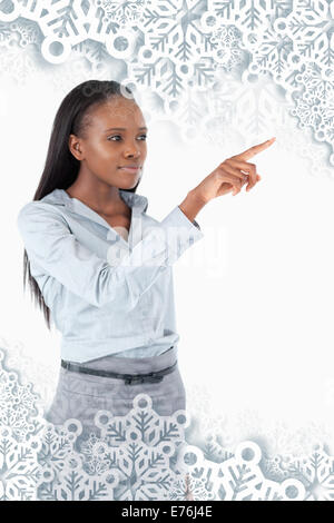 Composite image of young businesswoman en appuyant sur une touche invisible Banque D'Images