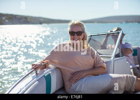 Femme plus âgée assis dans un bateau sur l'eau Banque D'Images