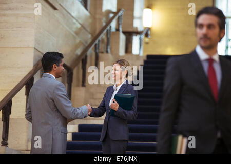 Lawyers shaking hands in courthouse Banque D'Images
