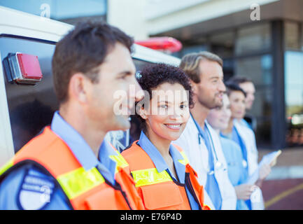 Les ambulanciers, les médecins et infirmières smiling par ambulance Banque D'Images