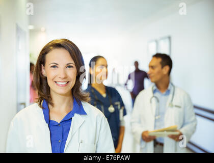 Doctor smiling in hospital hallway Banque D'Images