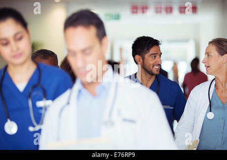 Médecins et infirmières parler in hospital hallway Banque D'Images