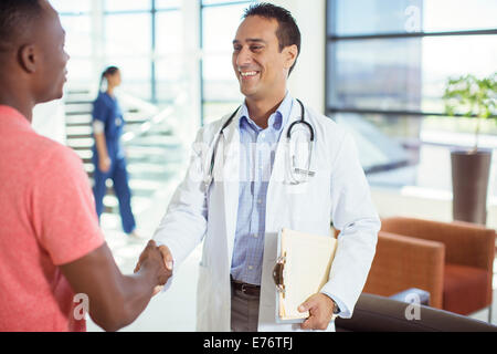 Médecin et patient shaking hands in hospital Banque D'Images