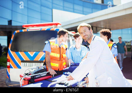 Médecin avec les ambulanciers à l'extérieur de l'hôpital Banque D'Images