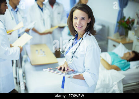 Doctor using digital tablet in hospital room Banque D'Images