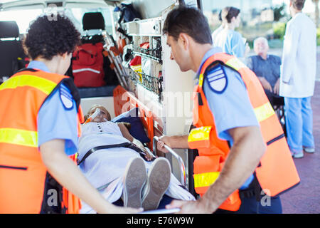 Les ambulanciers examining patient in ambulance Banque D'Images