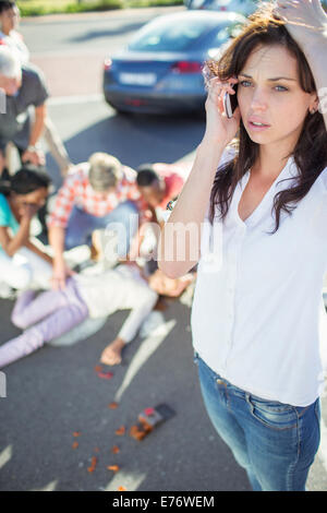 Femme appelant les services d'urgence à l'accident de voiture Banque D'Images