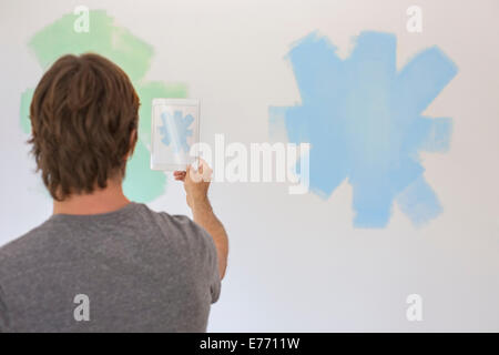 Man taking photo of wall with digital tablet Banque D'Images