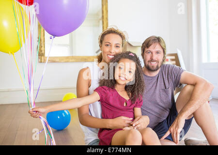 Family sitting in living space with balloons
