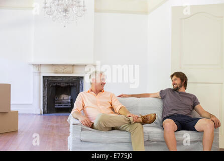 Père et fils assis sur table en l'espace de vie Banque D'Images