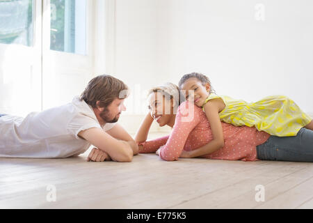 Pose de la famille sur le terrain ensemble dans l'espace de vie Banque D'Images