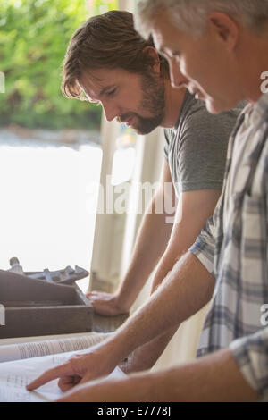 Père et fils à la recherche à travers des documents ensemble Banque D'Images