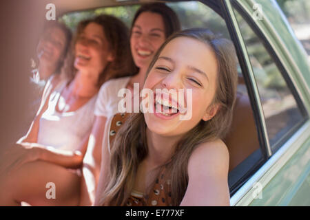 Quatre femmes jouant en voiture backseat Banque D'Images