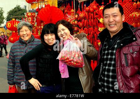 PENGZHOU, CHINE : une famille nouvellement acheté avec la décoration du Nouvel An chinois à l'extérieur du marché au Long Xing Square Banque D'Images