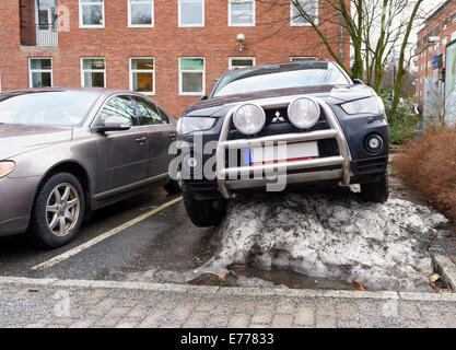 4x4 SUV voiture garée dans une manière habituelle sur le dessus d'un gros tas de neige. Hôpital Sahlgrenska, Västra Götaland, en Suède. Communiqué de modèle : N° des biens : Non. Banque D'Images