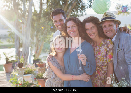 Family hugging outdoors sur sunny day Banque D'Images