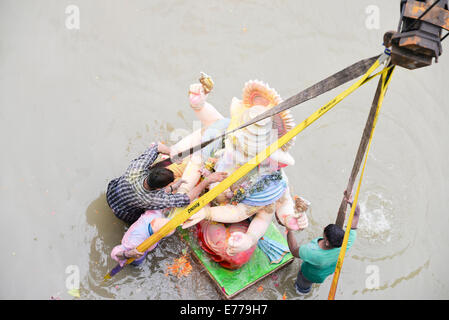 Ahmedabad, Gujarat/Inde. Sep 8, 2014. Les dévots portent une idole du dieu hindou Ganesh, la divinité de la prospérité, dans la rivière Sabarmati pour son immersion pendant les dix jours du festival Ganesh Chaturthi, à Ahmedabad, Inde. Credit : Nisarg Lakhmani/Alamy Live News Banque D'Images