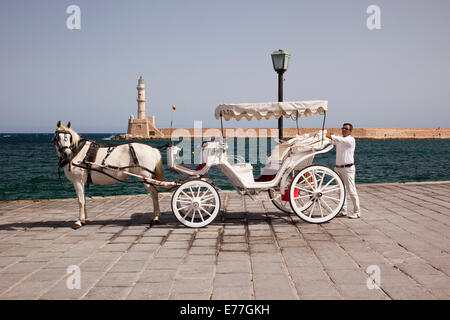 Calèche traditionnel avec phare en arrière-plan, Chania Harbour, Crète, Grèce Banque D'Images