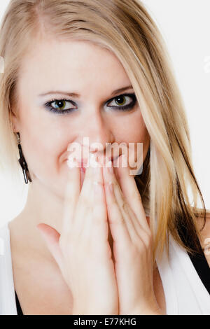 Le langage du corps et des émotions. Surpris fille blonde jeune femme choquée couvrant la bouche à part isolé sur blanc. Banque D'Images