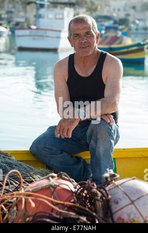 Tôt le matin, au port de Marsaxlokk à Malte où les pêcheurs peuvent être trouvés à assister à leurs bateaux Banque D'Images