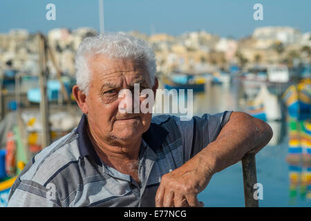 Tôt le matin, au port de Marsaxlokk à Malte où les pêcheurs peuvent être trouvés à assister à leurs bateaux Banque D'Images