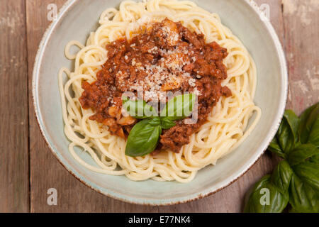 Spaghettis à la bolognaise dans un bol bleu d'argile sur table en bois Banque D'Images