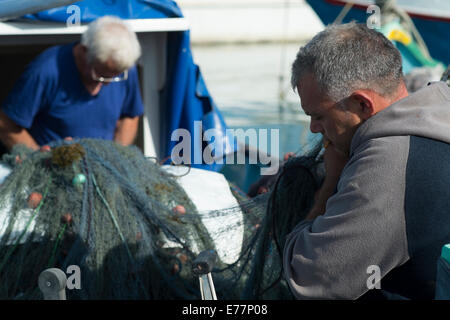 Tôt le matin, au port de Marsaxlokk à Malte où les pêcheurs peuvent être trouvés à assister à leurs bateaux Banque D'Images