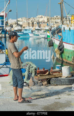 Tôt le matin, au port de Marsaxlokk à Malte où les pêcheurs peuvent être trouvés à assister à leurs bateaux Banque D'Images