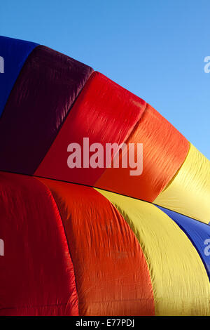 Détail d'un ballon à air chaud d'être gonflées dans early morning light against a blue sky Banque D'Images